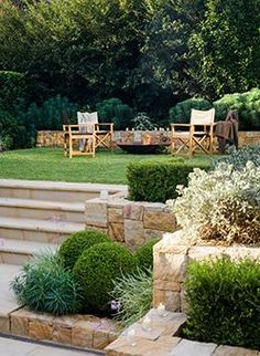 an outdoor garden with steps, bushes and lawn furniture in the back yard or patio area