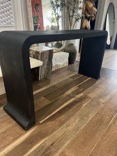 a wooden table sitting on top of a hard wood floor next to a planter