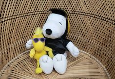 a stuffed dog with sunglasses sitting next to a small stuffed toy winnie the pooh