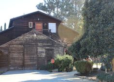 an old wooden building sitting next to a tree