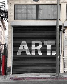 a large garage door with the word art painted on it in front of a building