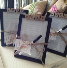 two framed memos tied with twine and some writing on them are sitting next to each other