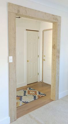 an empty room with a door and rug on the floor