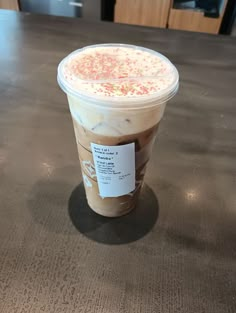 a cup of iced coffee with sprinkles on the top sits on a table