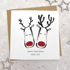 a christmas card with two reindeer heads on it