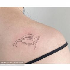 a woman's back with a tattoo on her left shoulder and an outline of a whale