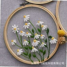 a close up of a cross stitch pattern with flowers in the hoop on a table