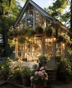 a small greenhouse with potted plants and lights in the windows is lit up at night