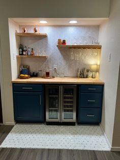 an empty kitchen with blue cabinets and shelves