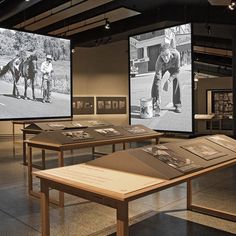 two large screens with pictures on them in a museum