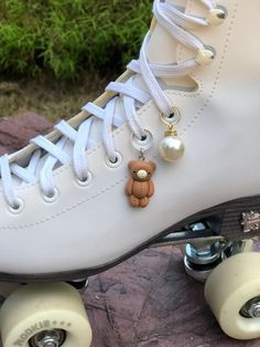 a close up of a skateboard with a teddy bear charm on it's shoe