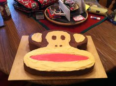 a cake shaped like a monkey sitting on top of a wooden table next to other items