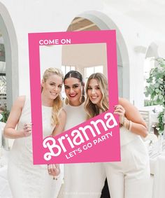 three women holding up a pink frame with the words braama let's go party