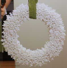 a white wreath hanging from the side of a wall next to a person holding a camera