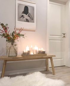 a table with candles on it in front of a white door and some pictures above the table