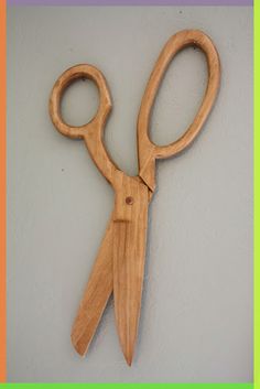 a pair of wooden scissors hanging on the wall