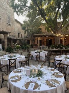 an outdoor dining area with tables and chairs set up for a formal function in the evening