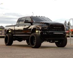 a large black truck parked on top of a parking lot