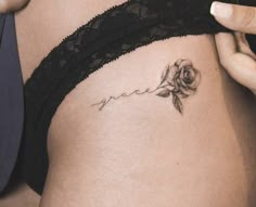 a woman's stomach with a rose tattoo on her side and the word grace written in cursive writing