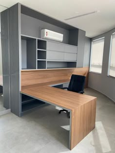 an empty office with a desk and chair in the middle, next to a window