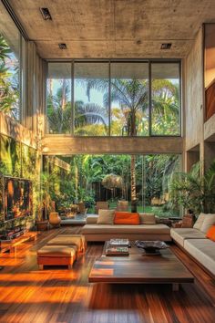 a living room filled with lots of furniture and large windows over the top of it