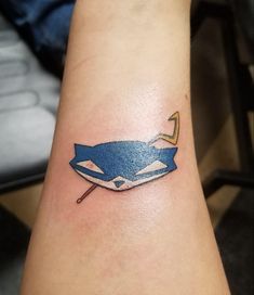 a blue and white whale tattoo on the arm