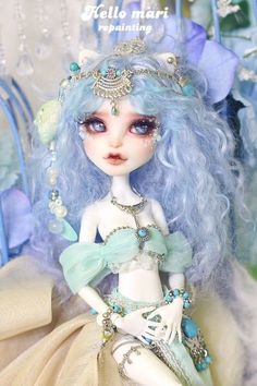 a close up of a doll with blue hair wearing a dress and jewelry on it's head