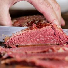 a person cutting up some meat with a knife