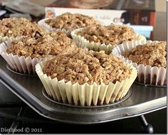 several muffins sitting on top of a metal tray in front of a book