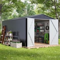 a storage shed with its doors open in the grass next to trees and flowers on either side