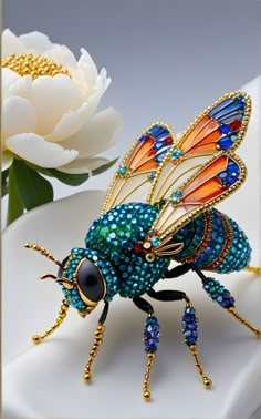 a blue and orange insect sitting on top of a white plate next to a flower