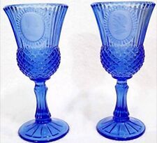 two blue glass goblets sitting next to each other on a white table top