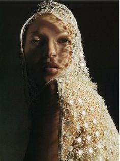 a woman wearing a veil with white flowers on it