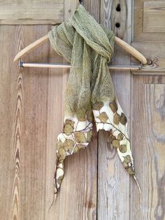 a green scarf hanging on a wooden door