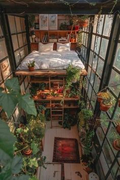 an indoor bedroom with lots of plants in the corner and a bed on top of it