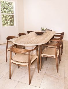 a dining room table with chairs around it and a bowl on top of the table