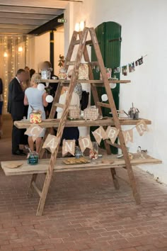 a wooden ladder with decorations on it and people standing around in the background at a party