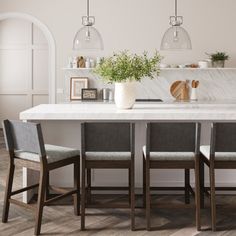 a kitchen with marble counter tops and chairs around the table, surrounded by hanging lights