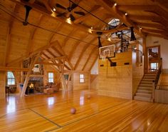 an indoor basketball court with hardwood floors and wooden walls is seen in this image from the inside