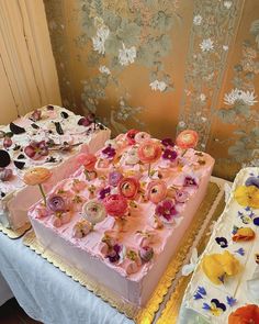 there are two cakes on the table and one is decorated with pink frosting flowers