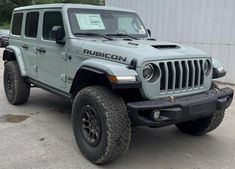 a gray jeep is parked in front of a building with a sign that says rubibon on it