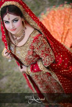 a woman in a red and gold bridal outfit