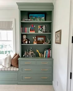 a green bookcase filled with lots of books and stuffed animals on top of it