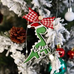 a christmas tree with ornaments hanging from it's branches and a dinosaur ornament