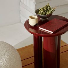 a small table with a book and a bowl on it next to a white ball