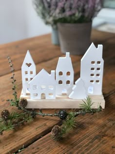 a small white house sitting on top of a wooden table