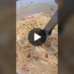 someone is cooking pasta in a pan with a spatula