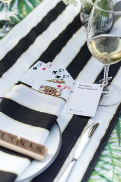 a place setting with wine glasses and cards