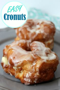 two glazed donuts sitting on top of a gray plate