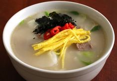 a white bowl filled with soup on top of a wooden table